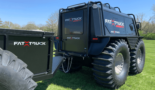 A black fat truck personnel carrier towing a trailer (1)