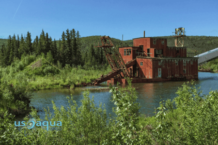 An old school dredging station in a small body of water in the middle of the mountains used for gold dredging. (1)