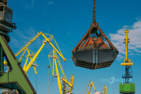 An orange clamshell bucket dredger on a crane provided by US Aqua  (1)