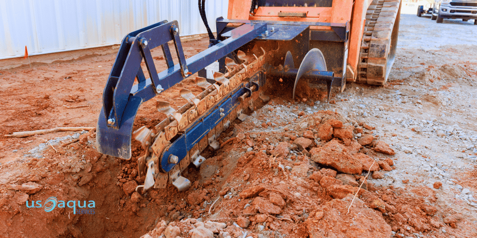 Mechanical chain trencher digging in clay ground