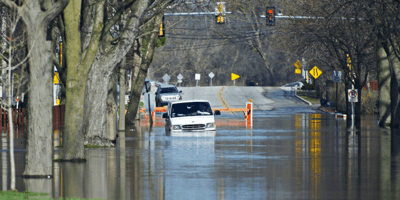 A van trying to drive down a flooded metro street in Chicago.