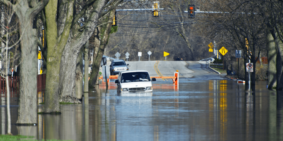 A van trying to drive down a flooded metro street in Chicago.