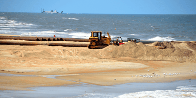 US Aqua's dredging equipment on coast representing their Oilfield Support Services