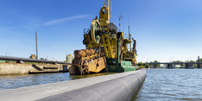 Pipeline with dredging boat in body of water